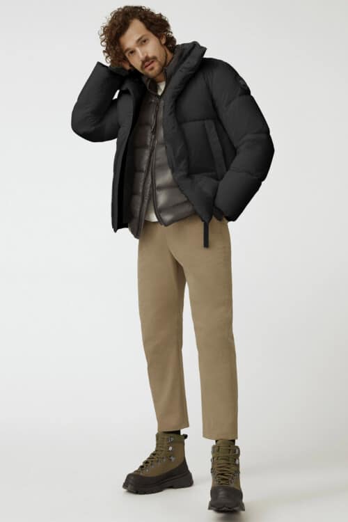 Men's khaki green pants, black puffer jacket, quilted gilet and green hiking boots outfit