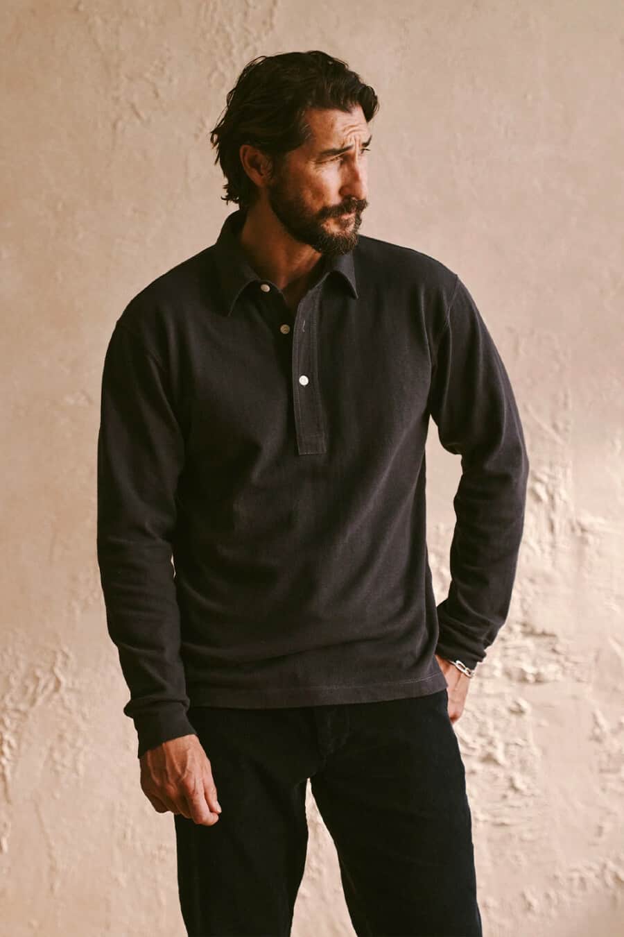 Man in his 40s wearing a black polo shirt and black jeans