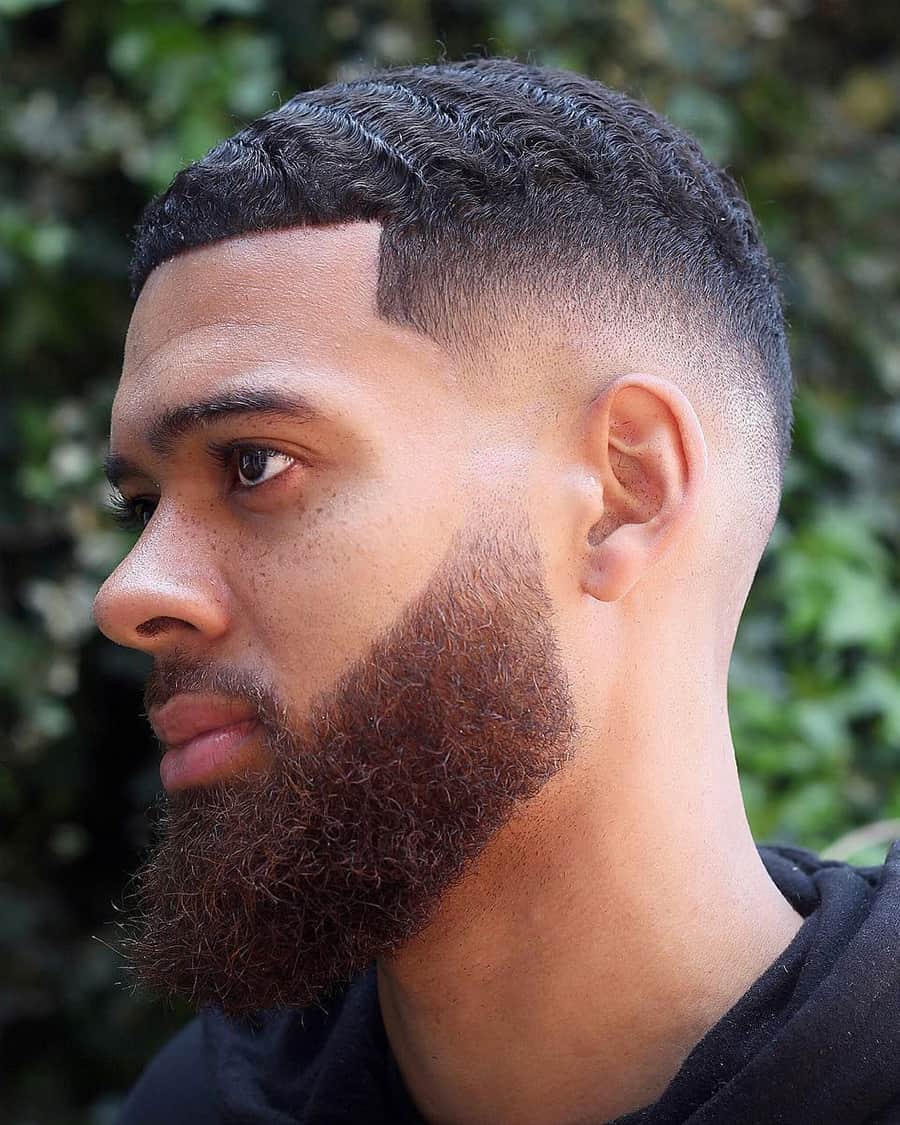 Black man with short waves, a line up and drop fade haircut