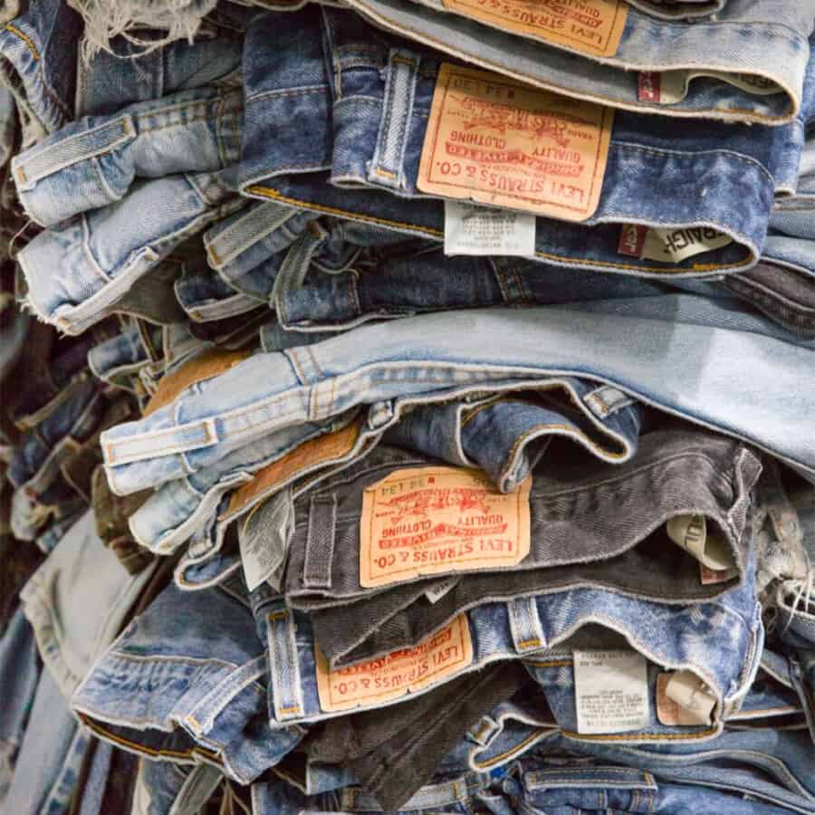 A pile of cheap men's Levi's jeans in a variety of washes from light blue to black