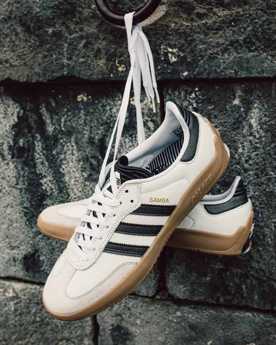 A pair of white affordable Adidas Samba sneakers hung up by laces