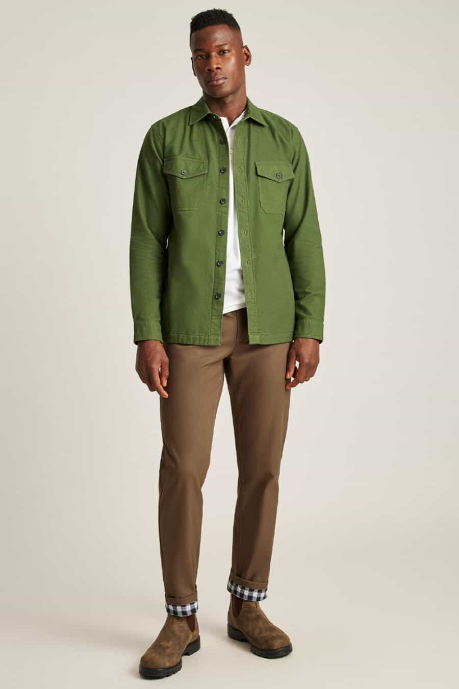 Men's brown pants, white T-shirt, green canvas overshirt and suede brown Chelsea boots outfit