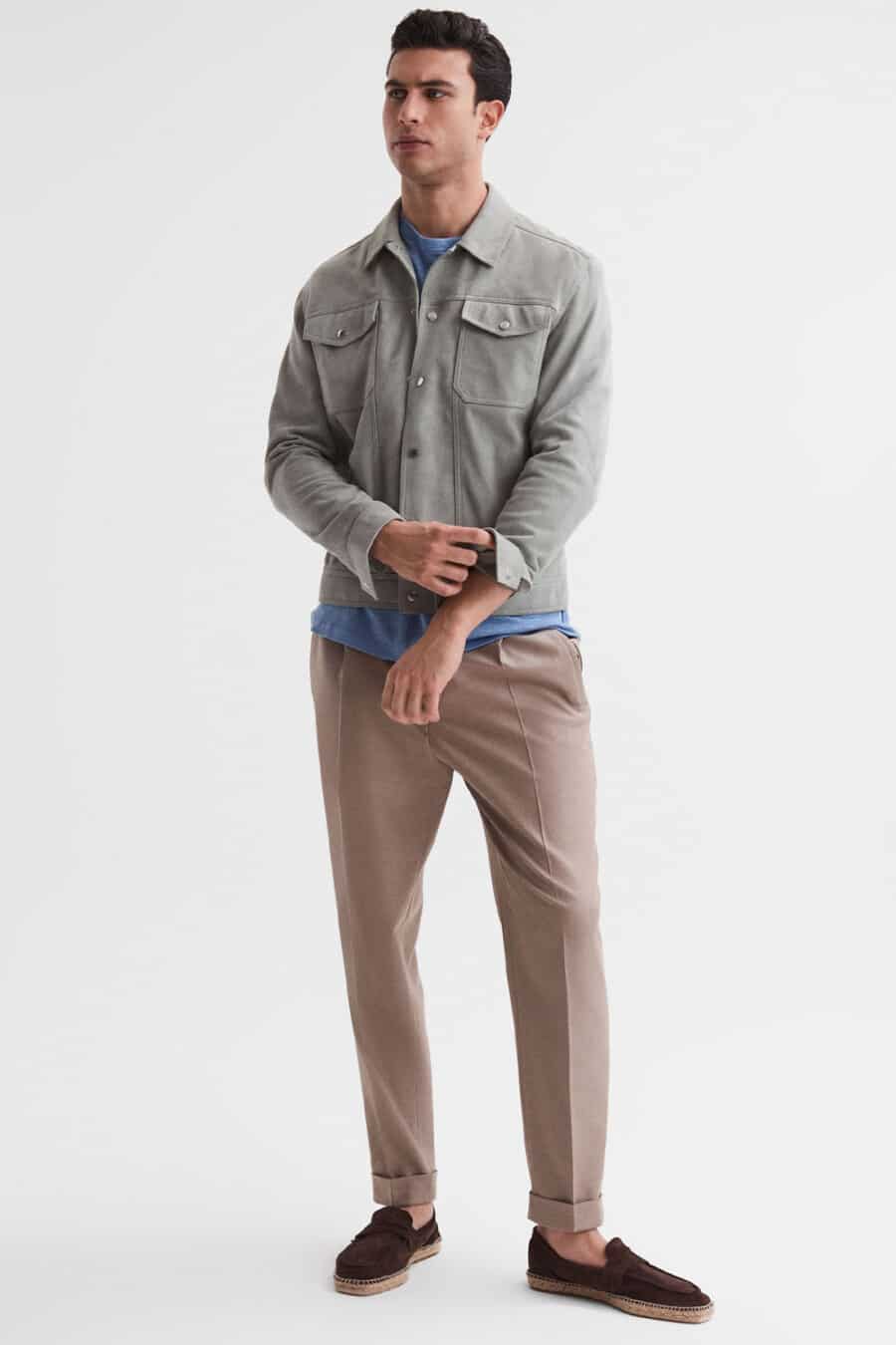Men's light brown pants, mid blue T-shirt, grey suede trucker jacket and brown suede loafer-espadrilles outfit