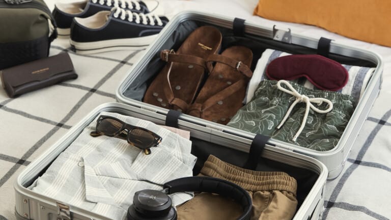 Luxury travel clothing for men packed in a suitcase for vacation