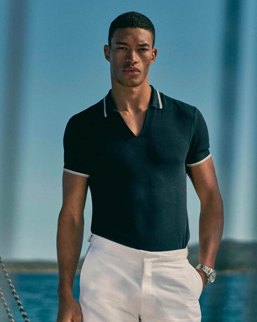 Men's luxury resortwear outfit with white trousers and knitted navy polo shirt