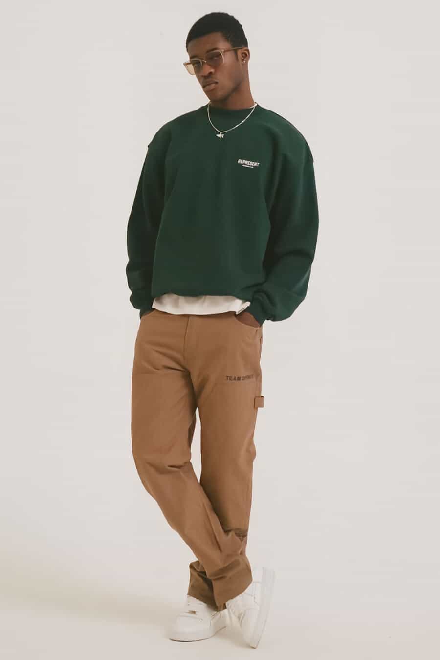 Men's khaki carpenter pants, white T-shirt, streetwear sweatshirt, chunky white sneakers and silver pendant chain necklace outfit