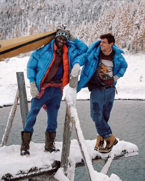 Two men wearing bright blue Moncler puffer jackets in the snow