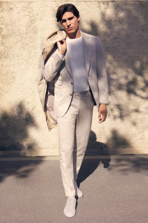 Men's high end white suit, tucked in white T-shirt and white sneakers outfit