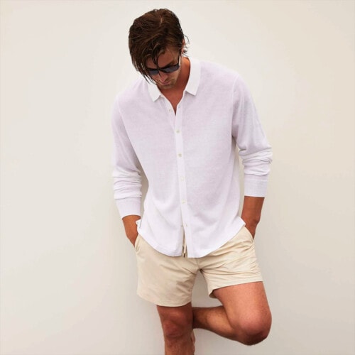 Man wearing a white James Perse shirt with khaki shorts and sunglasses