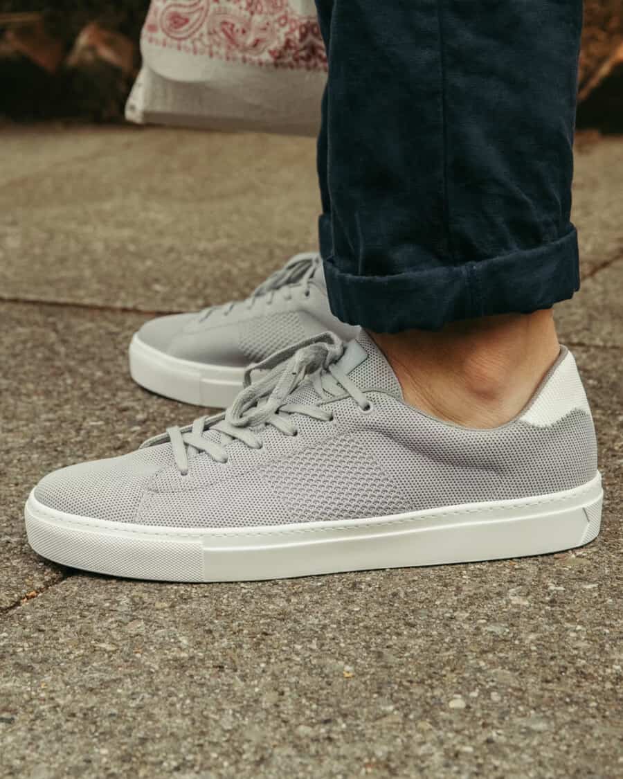 Greats Royale Knitted Sneakers in grey worn on feet with turned up navy chinos
