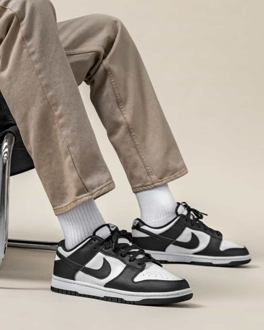 Nike Dunk Low sneakers worn on feet with white socks and khaki worker pants