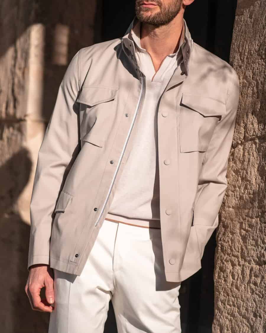 Men's luxury field jacket, knitted taupe polo shirt and off-white pants