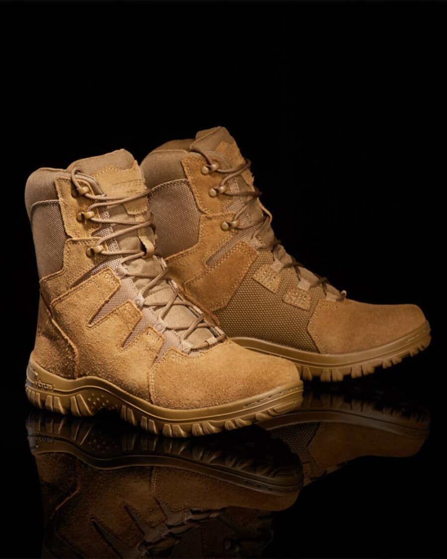 A pair of Bates beige tactical boots set against a black background