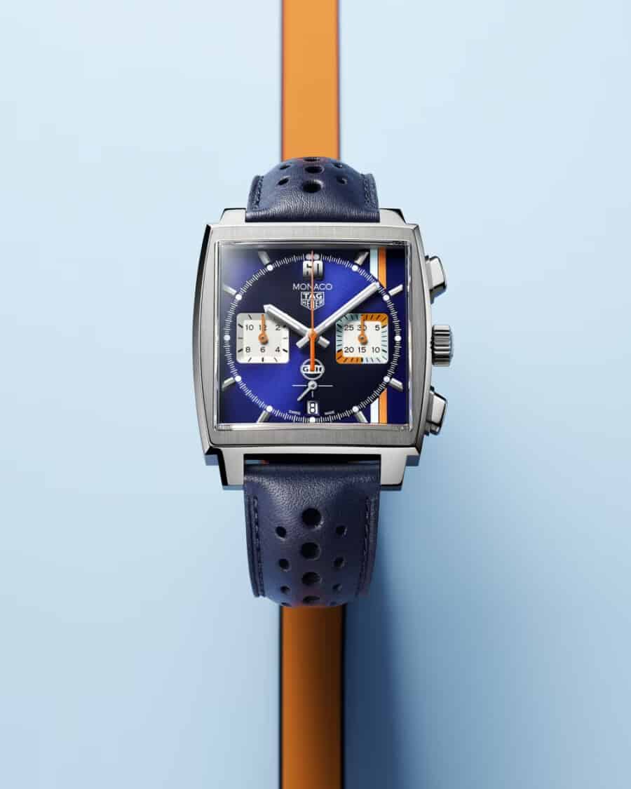 TAG Heuer Monaco Gulf Edition watch set on sky blue background with orange racing stripe