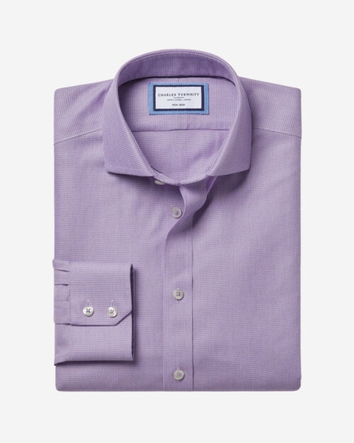 Dressing in a purple shirt, gray pants, a black tie, a young businessman  with a little beard and mustache is standing in the corner, looking  forward. / Waiting for You - Stock