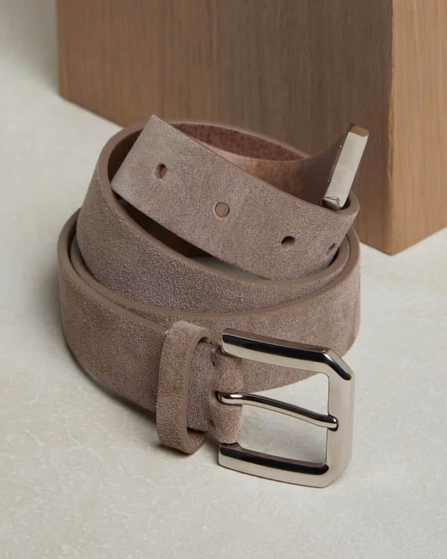 A coiled up luxury men's stone suede belt by Brunello Cucinelli