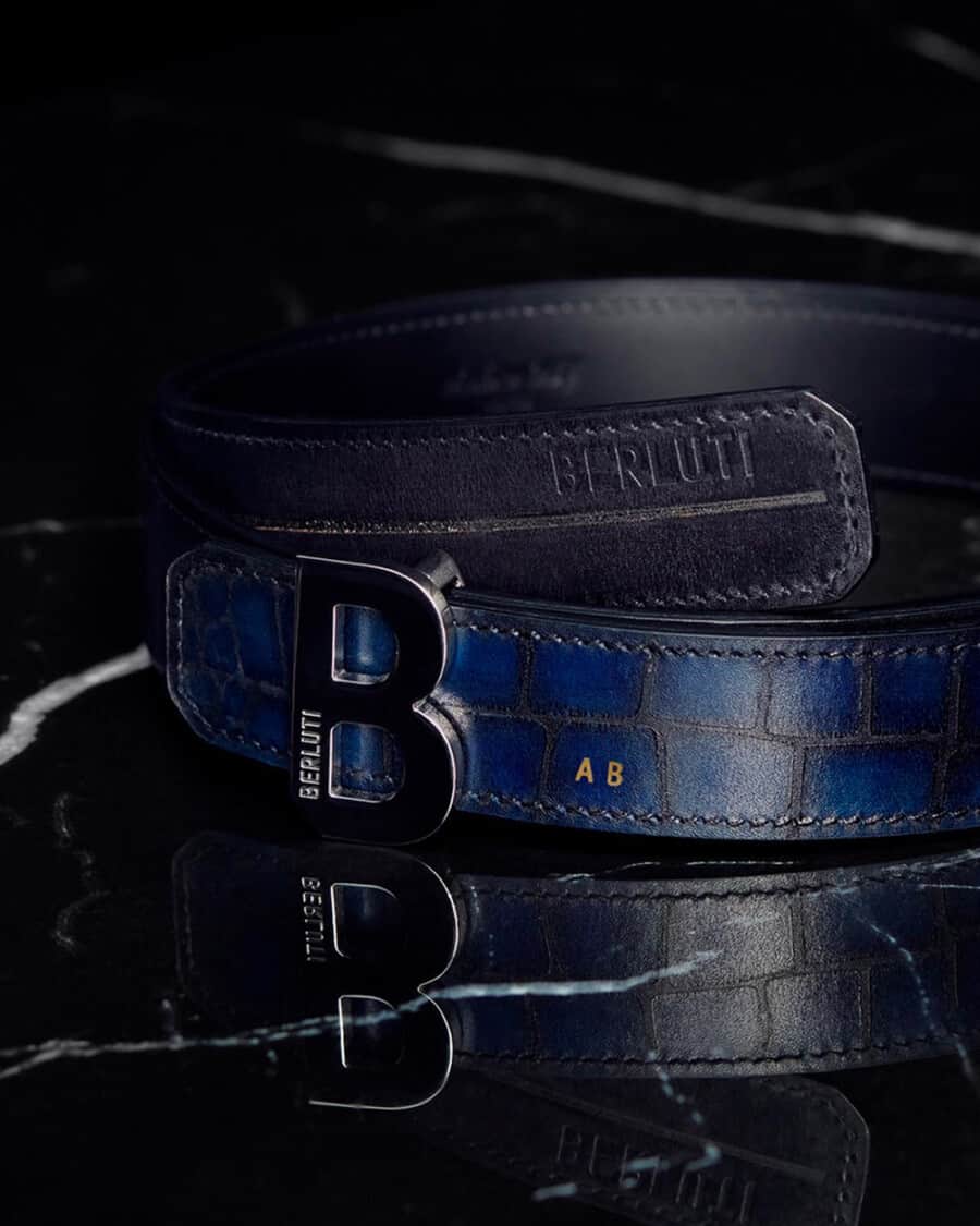 A luxury blue snakeskin men's Berluti belt with a B logo buckle