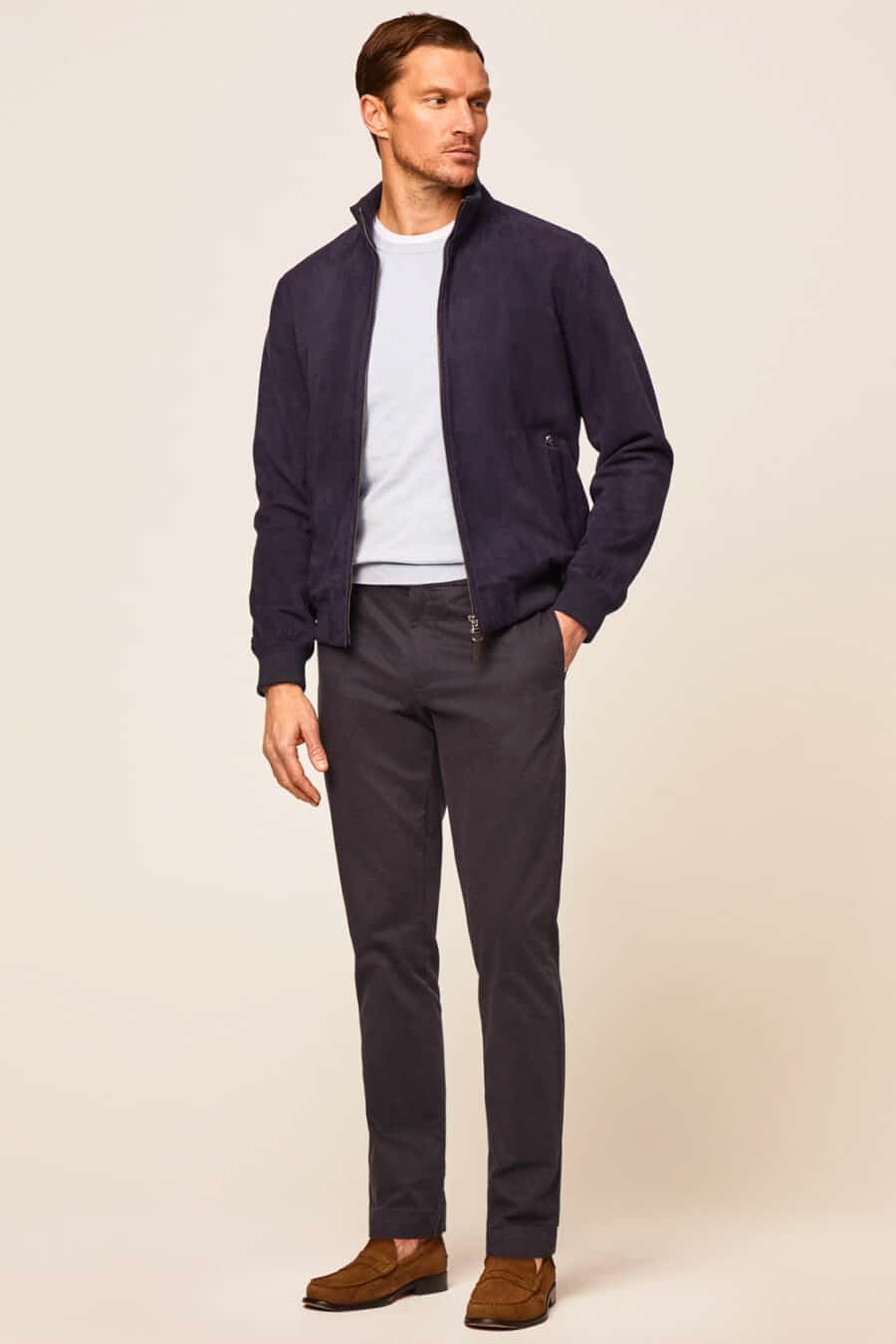 Men's navy chinos, white T-shirt, light grey sweater, navy bomber jacket and brown suede loafers outfit