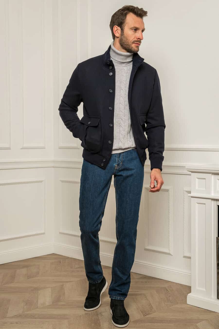 Men's blue jeans, grey cable knit roll neck jumper, blue wool bomber jacket and navy suede chukka boots outfit