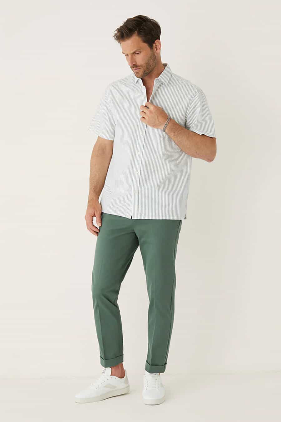 Men's cropped green turn up pants, short sleeve green/white stripe shirt and white sneakers outfit