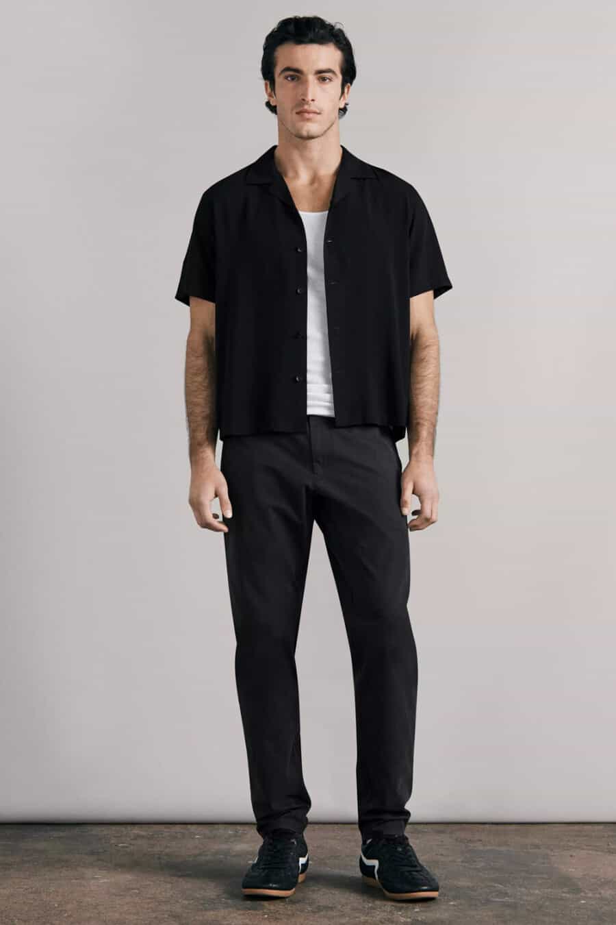 Men's black pants, white T-shirt, open black short-sleeve shirt and black sneakers outfit