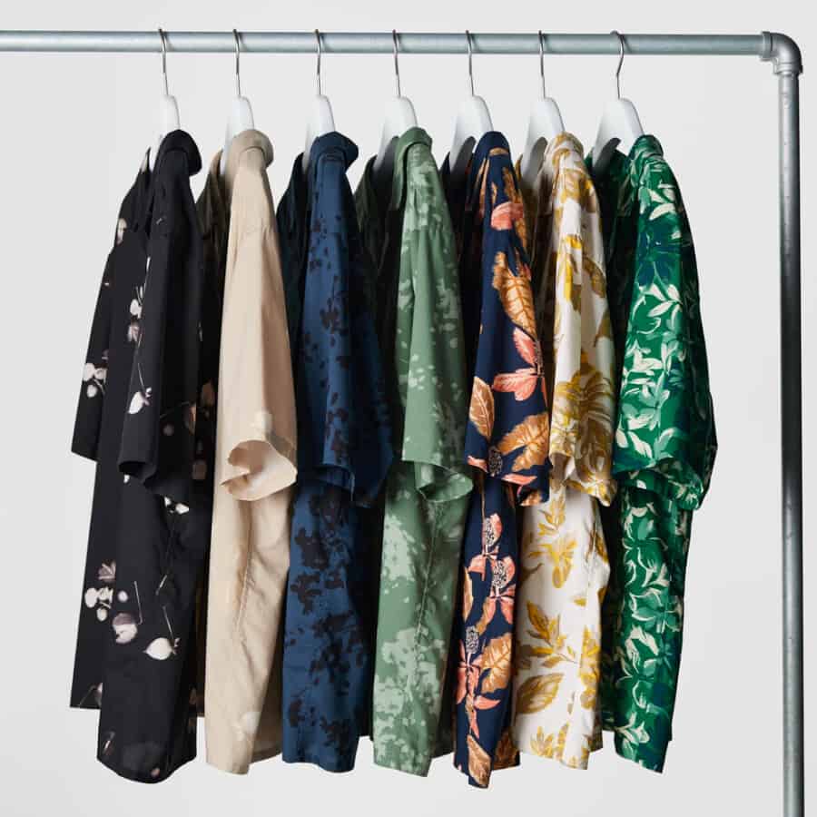 A selection of patterned short sleeve summer shirts for men hanging on a clothes rail