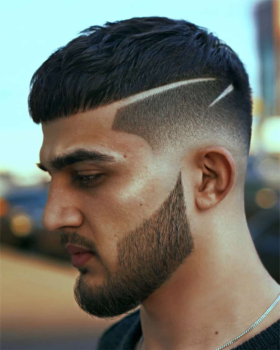 Men's Caesar haircut with low fade and clipper design lines