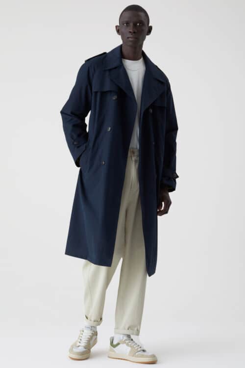Men's loose white pants, white T-shirt, navy trench coat and white sneakers outfit