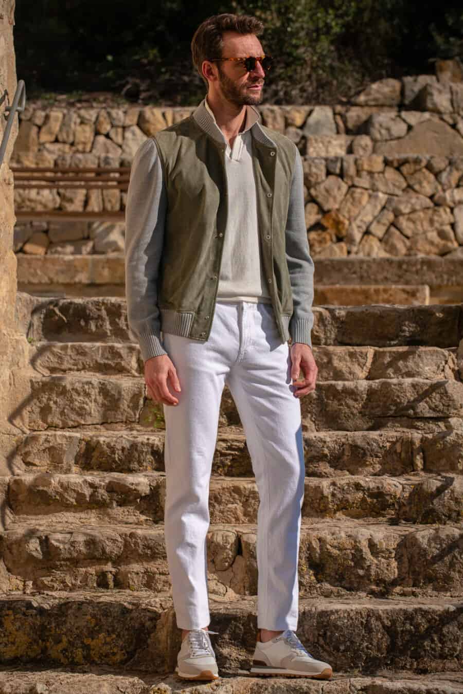 Men's white pants, cream knit polo shirt, green bomber jacket and white sneakers outfit