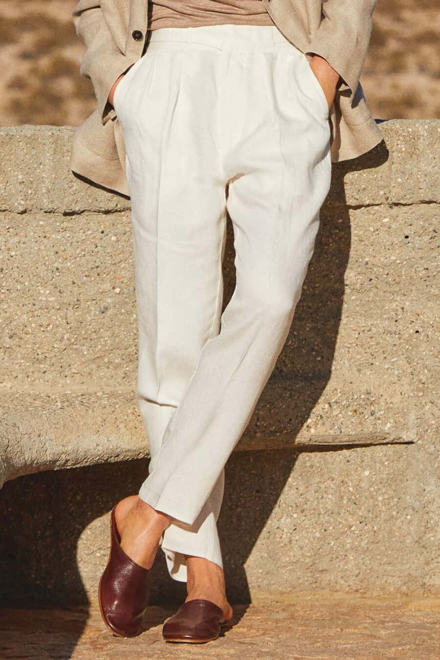 Man wearing white tailored, pleated pants with brown leather loafers