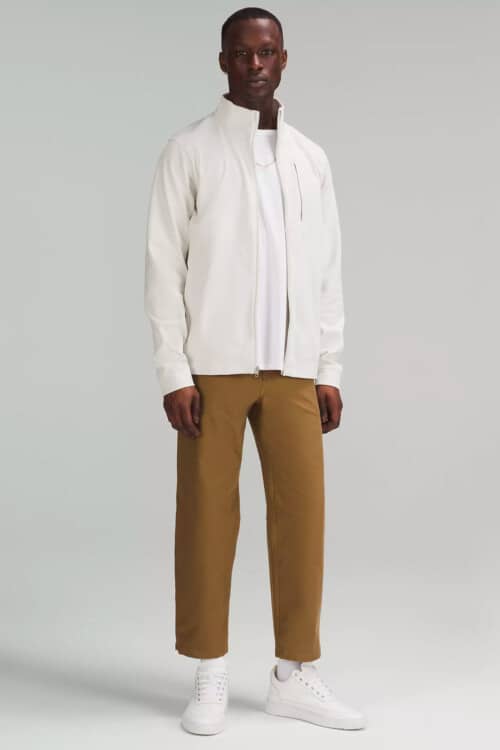 Men's relaxed khaki pants, white T-shirt, white technical jacket and white chunky sneakers outfit