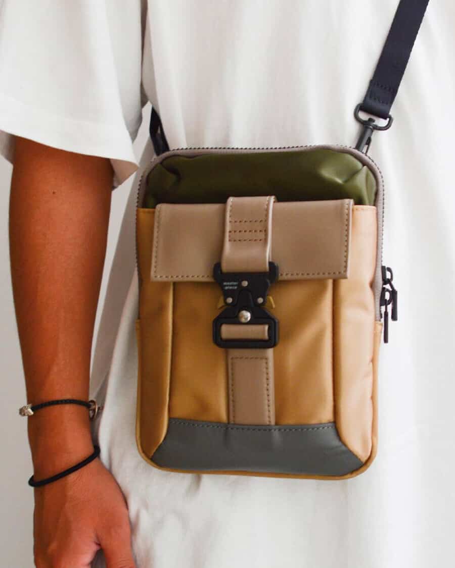 Man in white T-shirt wearing a mixed colour luxury crossbody Master-Piece bag