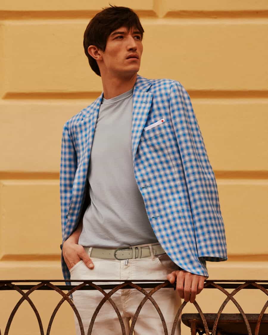 Man wearing high quality Kiton blue checked blazer with a grey T-shirt and off-white pants
