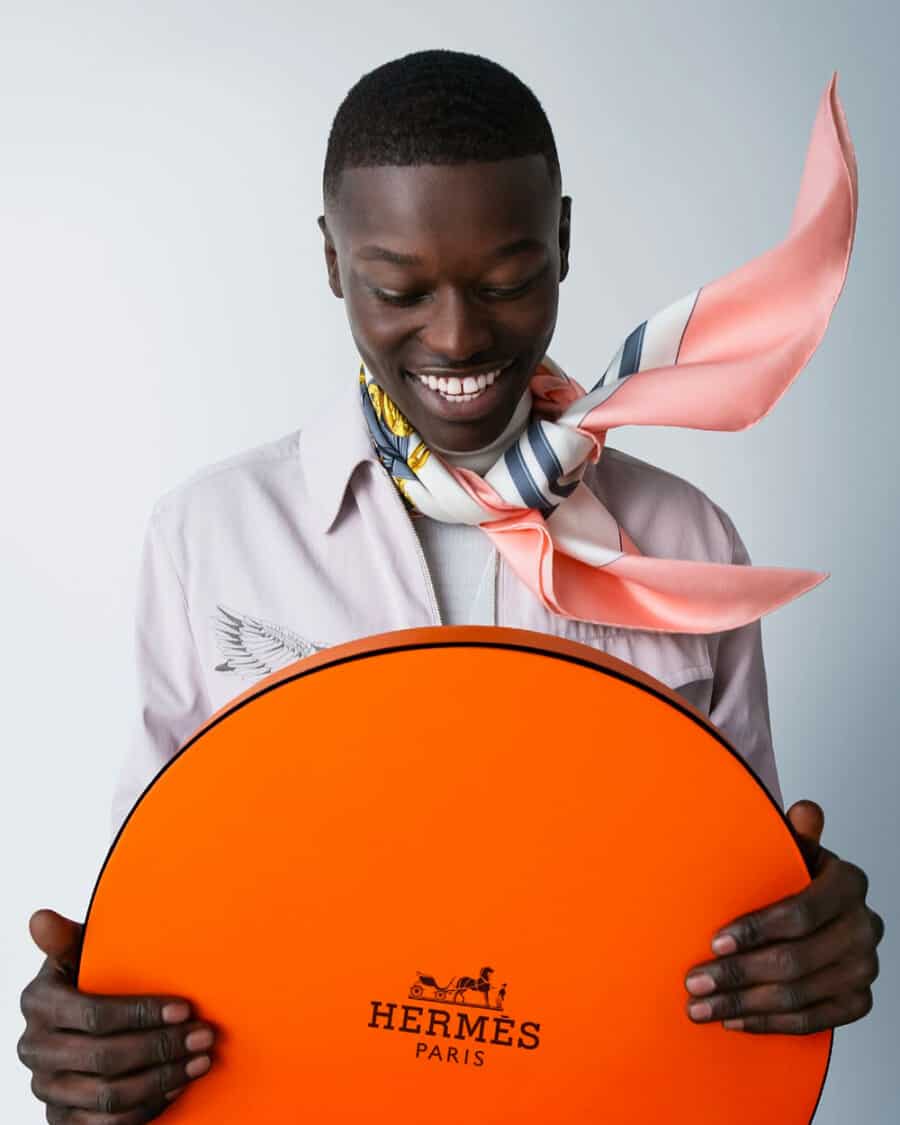 Man holding a Hermès sign