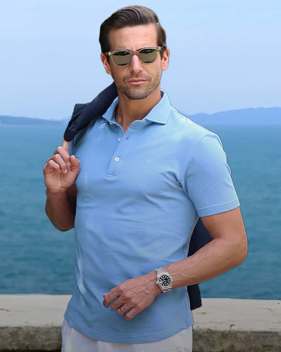 Man wearing sky blue Collars & Co polo shirt with white pants and sunglasses