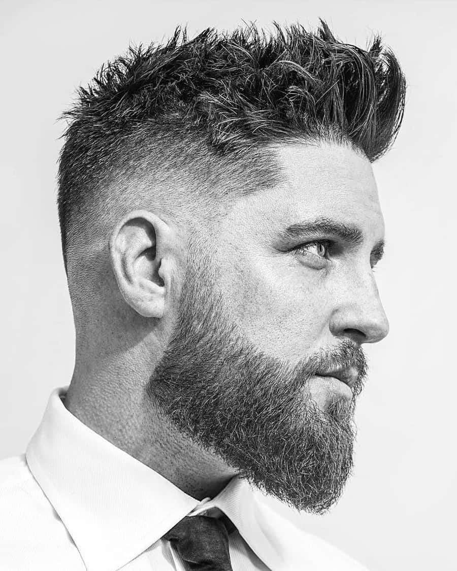Man with a spiky faux hawk haircut, taper fade and full beard