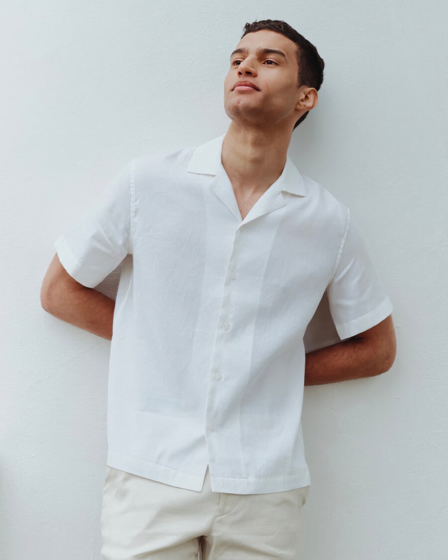 Man wearing a white linen Cuban collar shirt with beige shorts