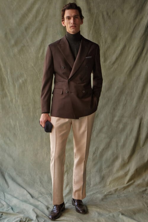 Men's khaki pants, navy turtleneck, brown double-breasted blazer and brown leather penny loafers outfit