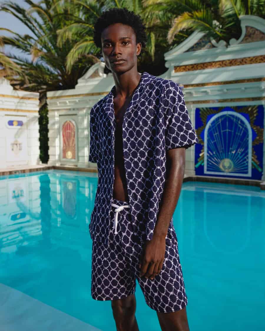 Black man wearing a matching swim short and shirt set