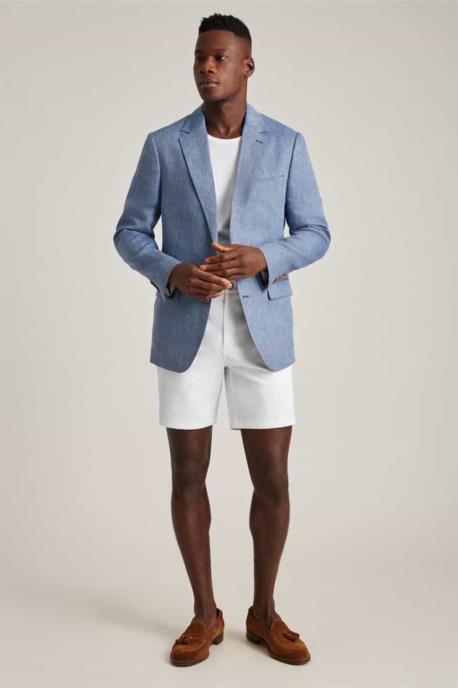 Men's white shorts, white T-shirt, light blue blazer and cognac brown suede tassel loafers outfit