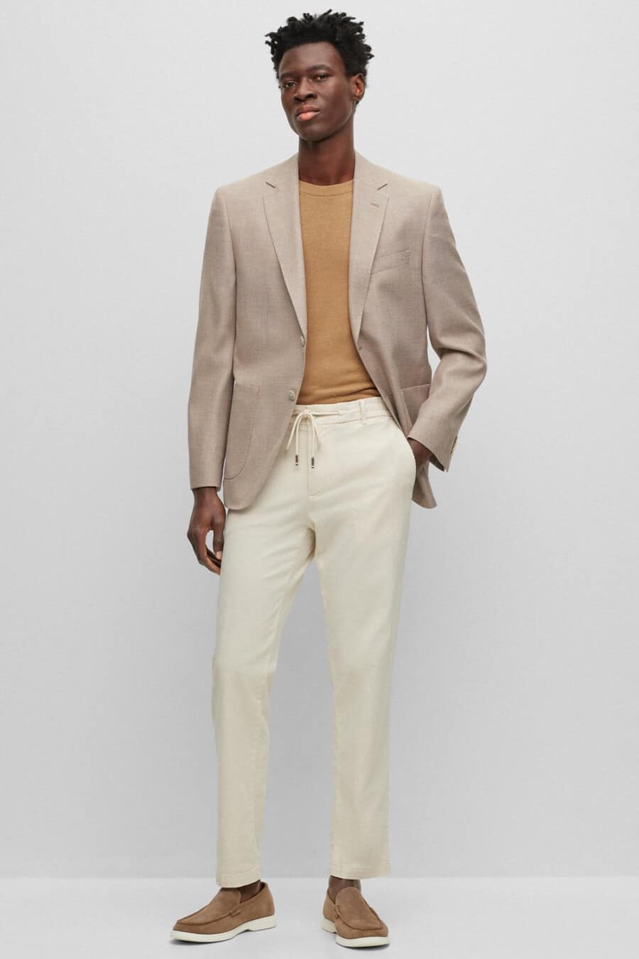 Men's stone drawstring pants, tan T-shirt, light brown blazer and brown suede loafers outfit