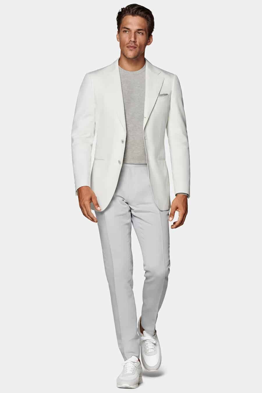 Men's grey pants, light grey T-shirt, white blazer and white sneakers outfit