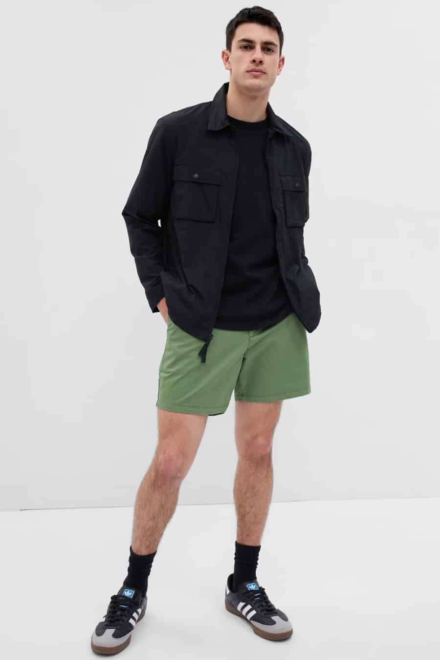 Men's light green athletic shorts, black T-shirt, black overshirt and black socks and sneakers outfit