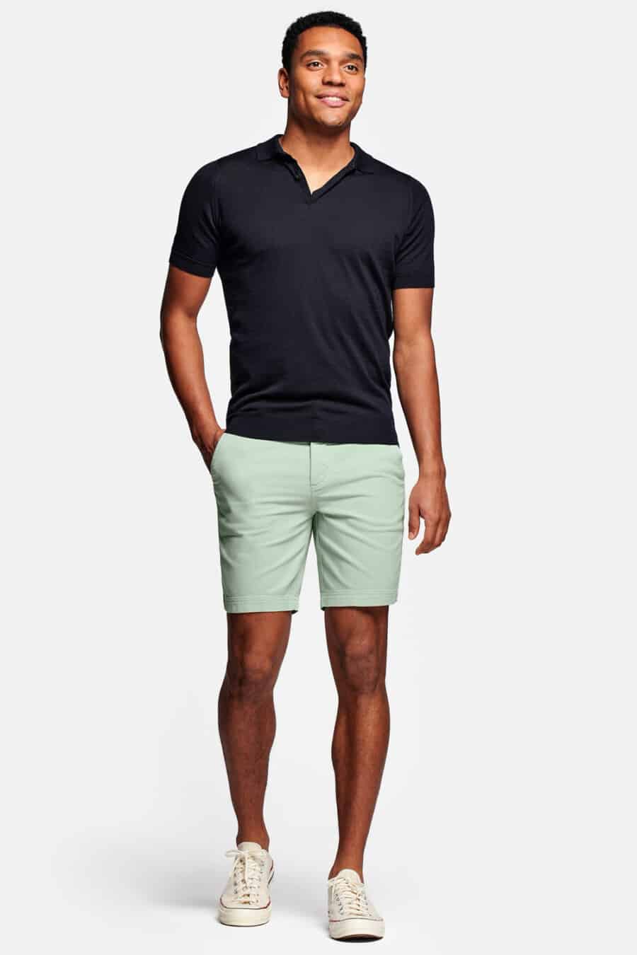 Men's Pastel green Bermuda shorts, navy polo shirt and off-white canvas sneakers outfit