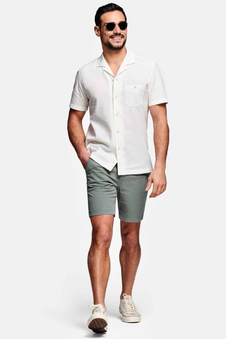 Men's green shorts, white camp collar shirt and off-white canvas sneakers outfit