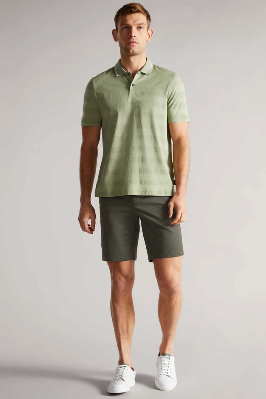 Men's dark green shorts, light green polo shirt and white sneakers outfit