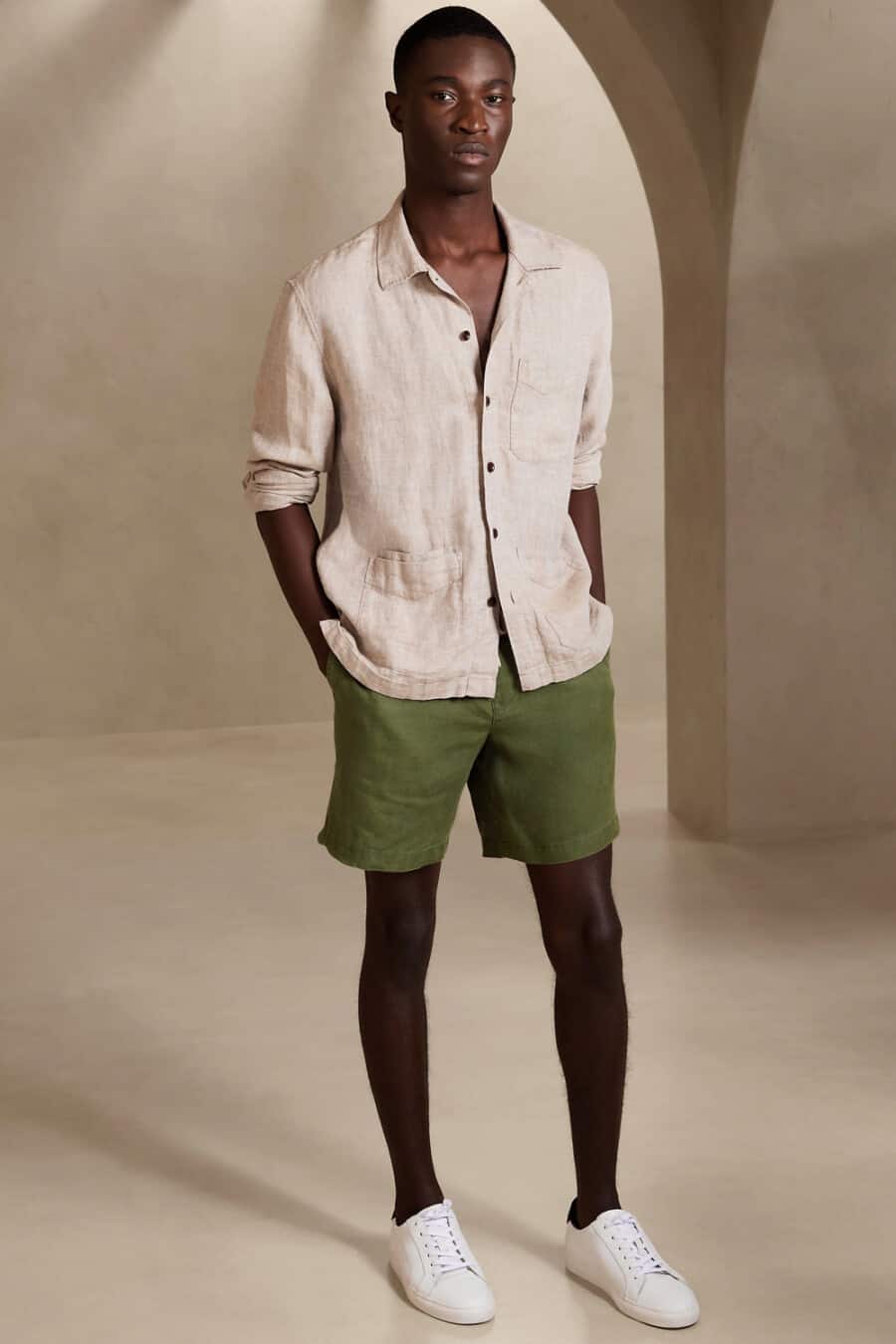 Men's green shorts, beige linen shirt and white sneakers outfit