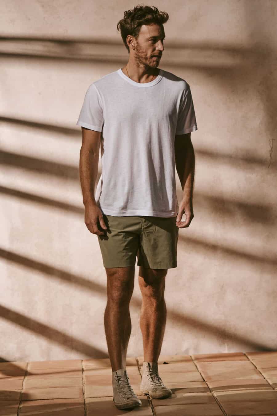 Men's green shorts, white T-shirt and off-white canvas high-top sneakers outfit