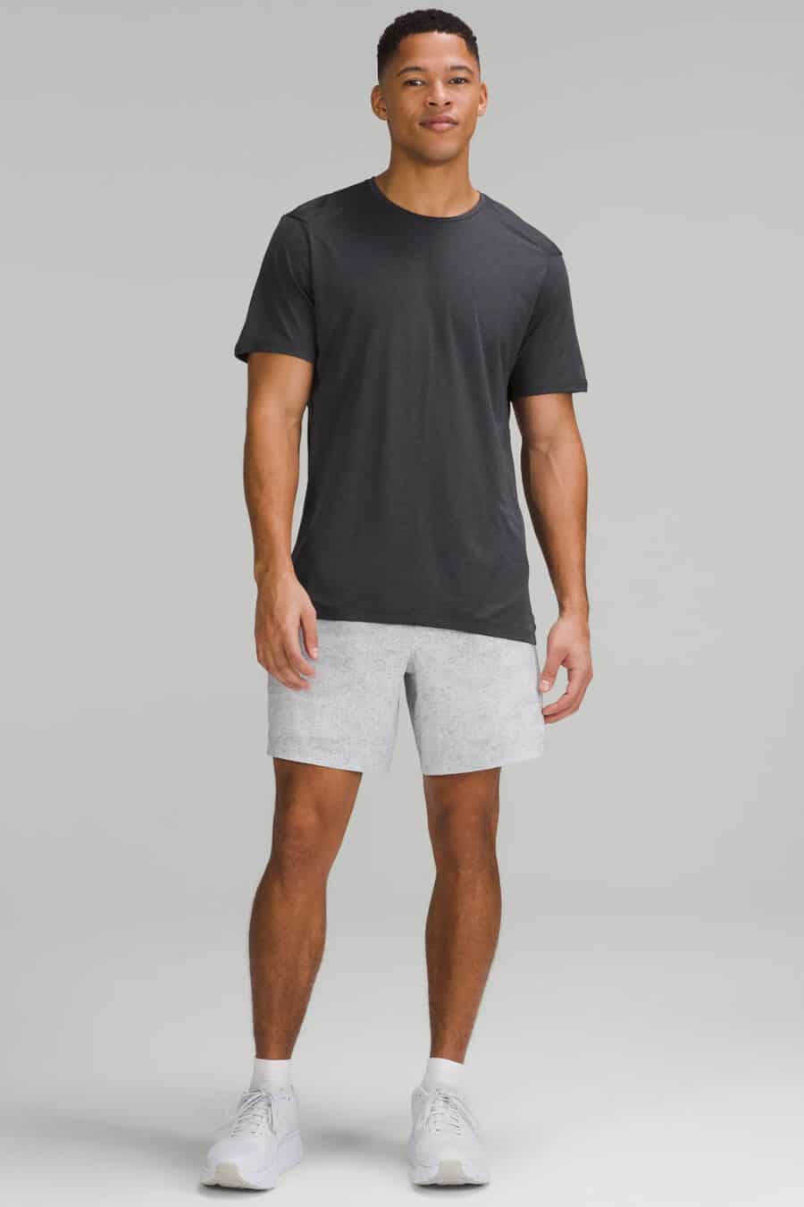 Men's grey athletic shorts, black T-shirt, white socks and white running sneakers outfit