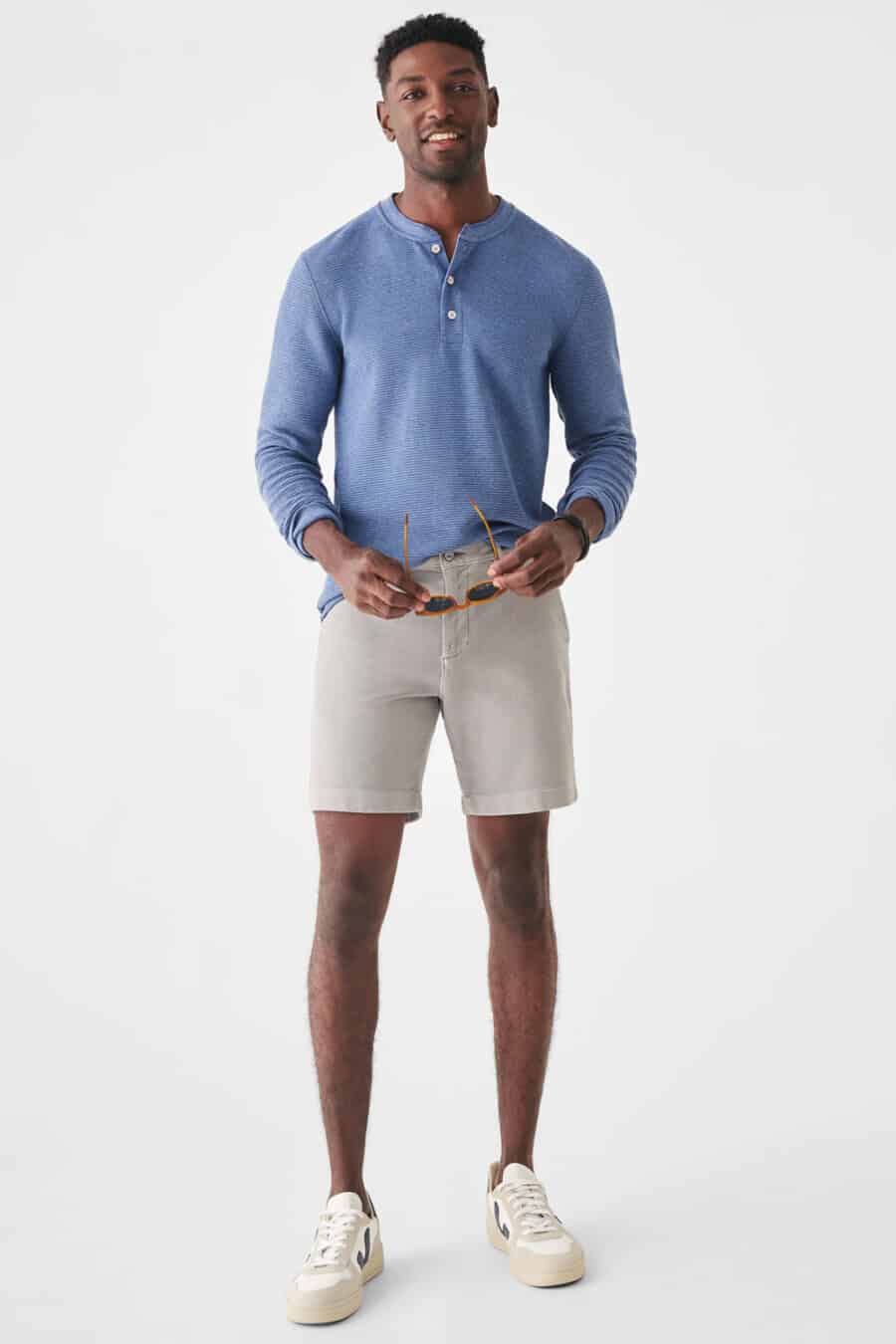 Men's light grey shorts, baby blue Henley shirt and white sneakers outfit